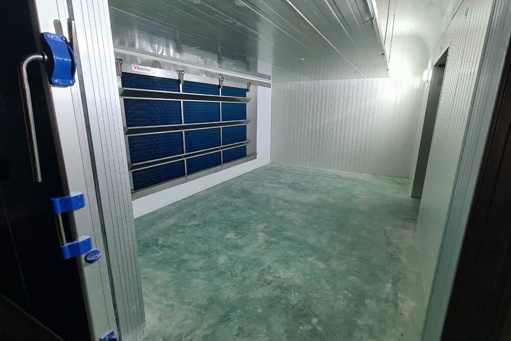 Inside an air blast freezer: evaporator mounted on the panelled wall and the freezer door