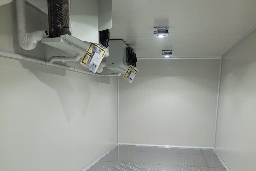Inside a frozen storage room: ceiling-mounted evaporator, panelled walls and an aluminium checker-plate floor